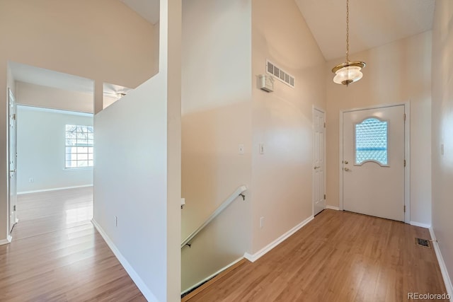 foyer with light hardwood / wood-style floors and high vaulted ceiling