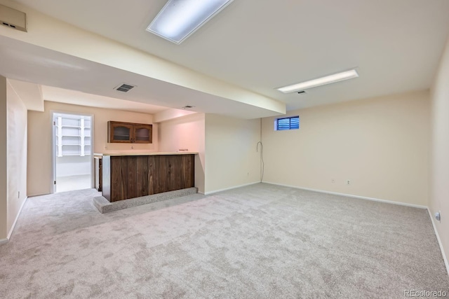 unfurnished living room with bar and light colored carpet