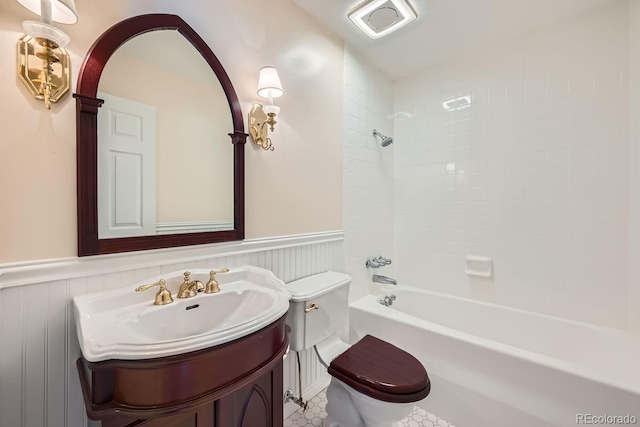 full bathroom with vanity, tiled shower / bath, and toilet