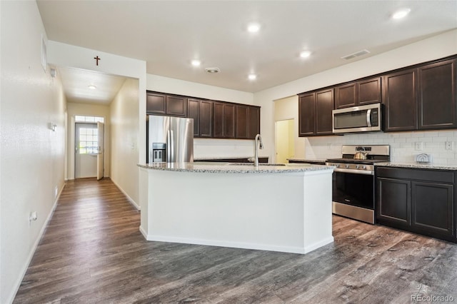 kitchen featuring stainless steel appliances, an island with sink, sink, and dark brown cabinetry