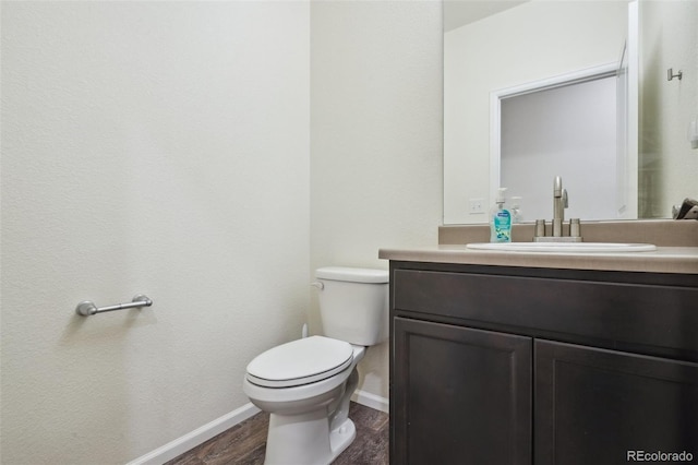 bathroom with hardwood / wood-style flooring, vanity, and toilet