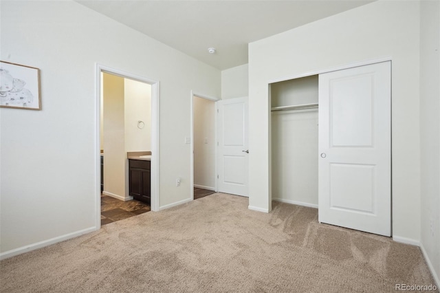 unfurnished bedroom featuring connected bathroom, carpet flooring, and a closet