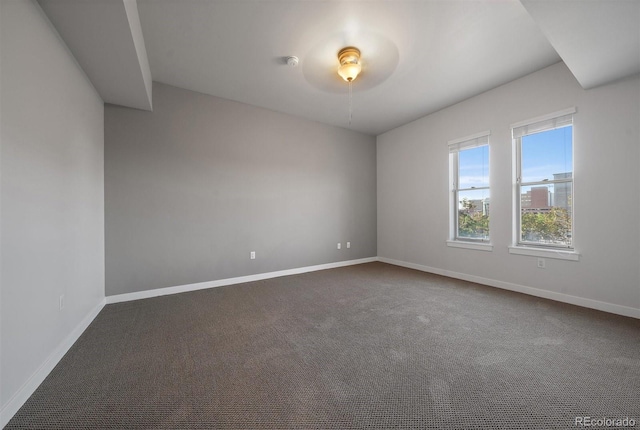 spare room featuring dark colored carpet