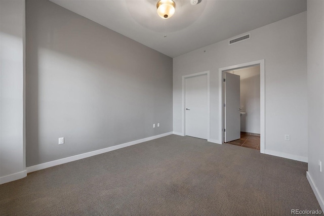 spare room with dark carpet