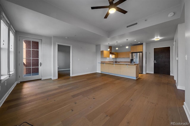 unfurnished living room with ceiling fan, hardwood / wood-style flooring, and sink