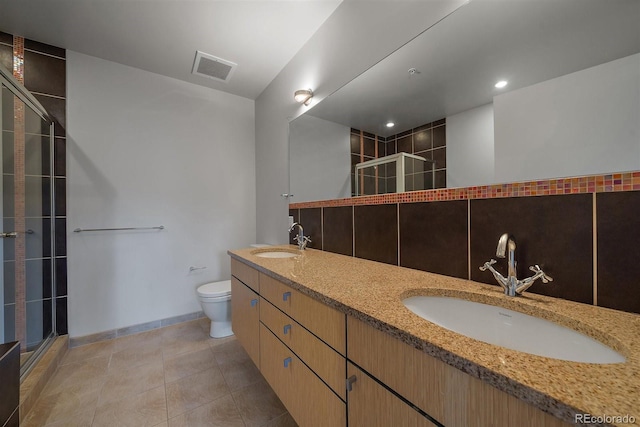 bathroom with toilet, vanity, tile patterned floors, and a shower with shower door