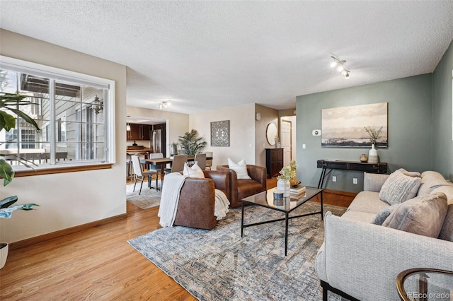 living room featuring a textured ceiling and light wood-type flooring