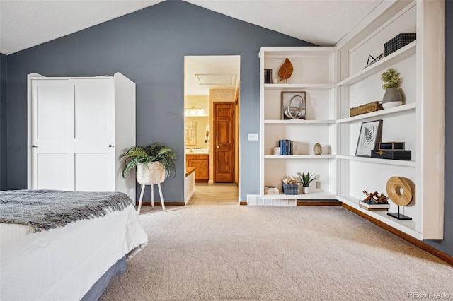 carpeted bedroom featuring connected bathroom and vaulted ceiling