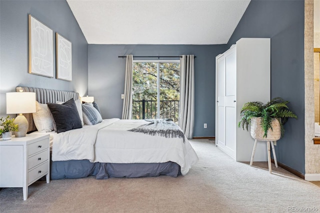 carpeted bedroom featuring access to exterior and vaulted ceiling