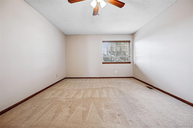 carpeted spare room with ceiling fan and a textured ceiling