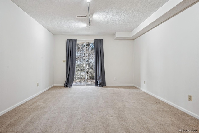 carpeted spare room with a textured ceiling