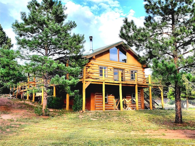 rear view of house featuring a deck and a yard