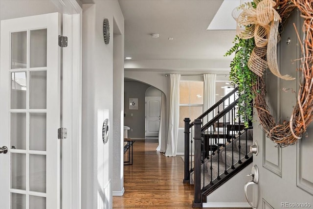 entryway featuring arched walkways, recessed lighting, stairway, wood finished floors, and baseboards