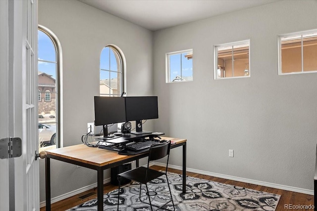 home office with baseboards and wood finished floors