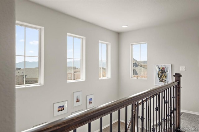 corridor with carpet flooring, baseboards, an upstairs landing, and recessed lighting