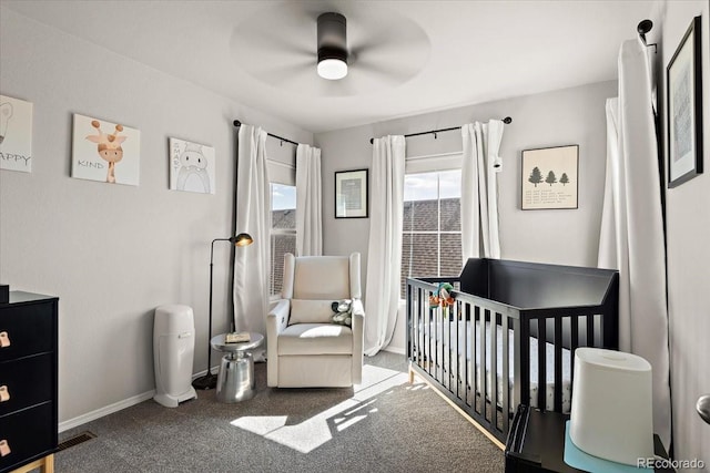bedroom featuring baseboards, carpet flooring, a ceiling fan, visible vents, and a nursery area