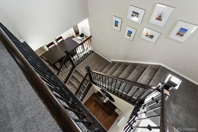 staircase with baseboards and carpet floors
