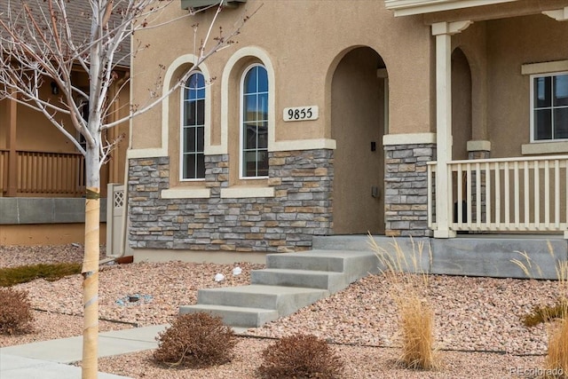 entrance to property with stone siding and stucco siding