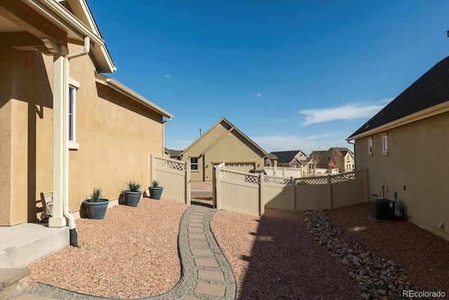 view of yard with a residential view, fence, and central AC