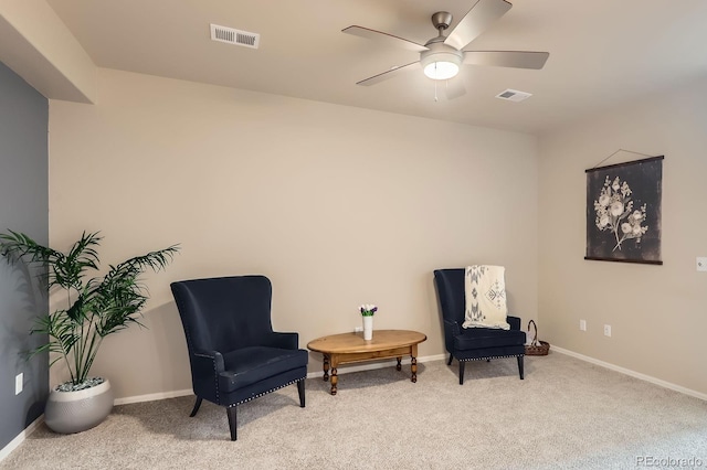 sitting room featuring visible vents, a ceiling fan, and carpet