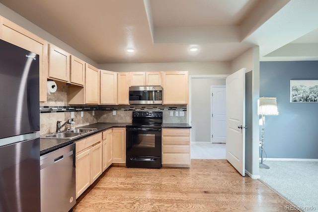kitchen with tasteful backsplash, light brown cabinetry, appliances with stainless steel finishes, a sink, and dark countertops