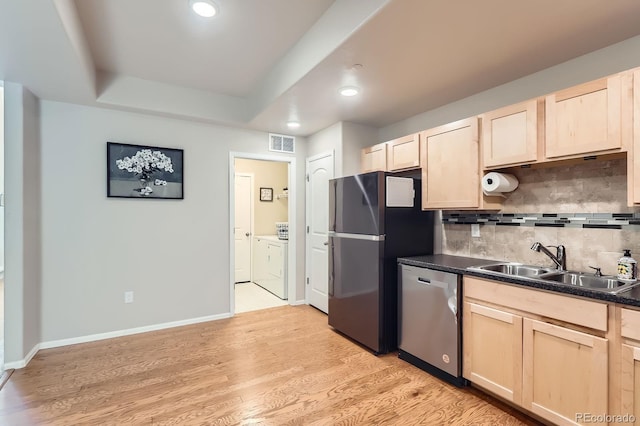 kitchen featuring a sink, appliances with stainless steel finishes, separate washer and dryer, and light brown cabinets