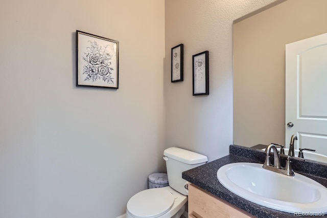 half bathroom with toilet and vanity