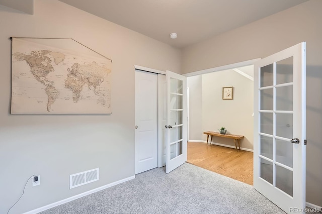 unfurnished bedroom featuring carpet flooring, french doors, baseboards, and visible vents