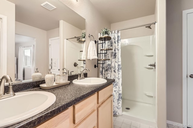 full bathroom with a shower with shower curtain, double vanity, visible vents, and a sink