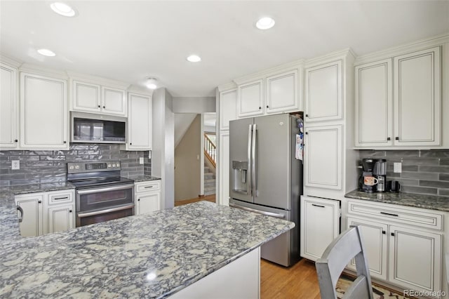 kitchen with recessed lighting, appliances with stainless steel finishes, stone counters, and tasteful backsplash