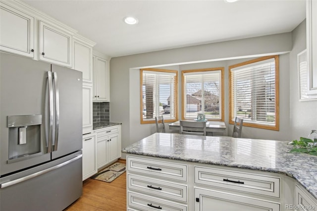 kitchen with decorative backsplash, stainless steel refrigerator with ice dispenser, recessed lighting, white cabinetry, and light wood-style flooring
