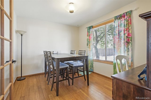 dining room with baseboards and light wood-style flooring