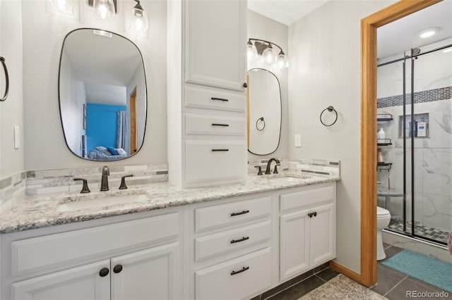 full bathroom with double vanity, toilet, a shower stall, and a sink