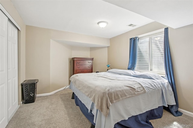 carpeted bedroom featuring baseboards, visible vents, and a closet