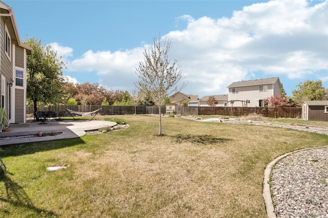 view of yard with a residential view, a shed, a fenced backyard, a patio area, and an outdoor structure