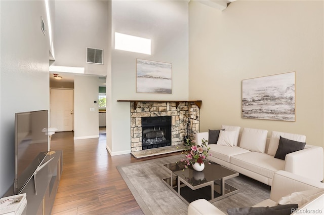 8635 Clay St Unit 417, Westminster, CO 80031 - living area featuring a towering ceiling, wood finished floors, baseboards, and a stone fireplace