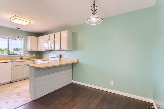 8635 Clay St Unit 417, Westminster, CO 80031 - kitchen with white appliances, a sink, baseboards, a peninsula, and light countertops