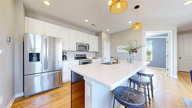 10016 Hough Pt, Parker, CO 80134 - kitchen with appliances with stainless steel finishes, a sink, white cabinets, light wood-style flooring, and recessed lighting