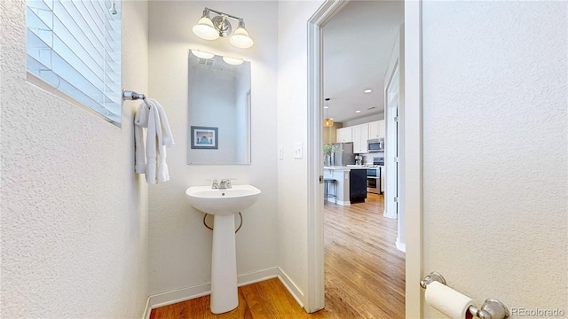 10016 Hough Pt, Parker, CO 80134 - bathroom featuring wood finished floors, baseboards, and a textured wall
