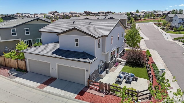 10016 Hough Pt, Parker, CO 80134 - view of front of home featuring a residential view, an outdoor living space, concrete driveway, stucco siding, and a tiled roof