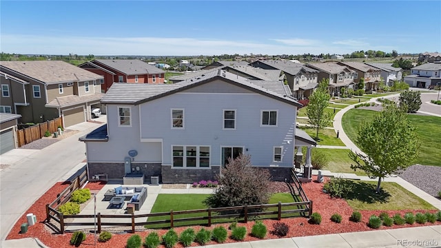 10016 Hough Pt, Parker, CO 80134 - rear view of house featuring a residential view, driveway, an attached garage, stone siding, and an outdoor living space