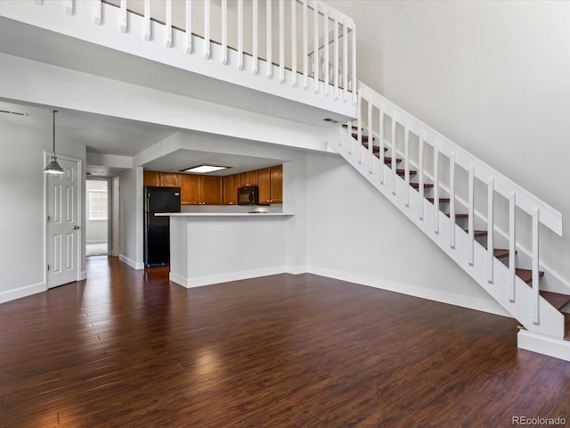 12403 E Tennessee Cir Unit E, Aurora, CO 80012 - unfurnished living room featuring dark wood-style flooring and stairway