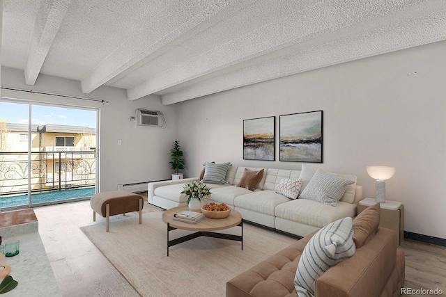 living room featuring a wall mounted air conditioner, beamed ceiling, a textured ceiling, wood finished floors, and baseboards