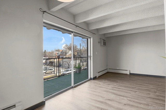 empty room featuring baseboard heating, beamed ceiling, a textured ceiling, and baseboards