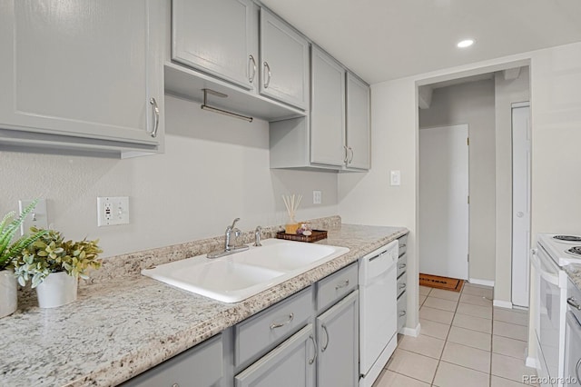 kitchen featuring gray cabinets, white appliances, and a sink