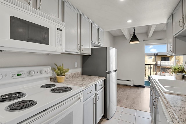 kitchen with a sink, a baseboard heating unit, white appliances, and light countertops