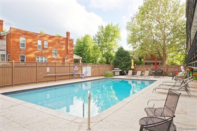 pool featuring grilling area, a patio, and a fenced backyard