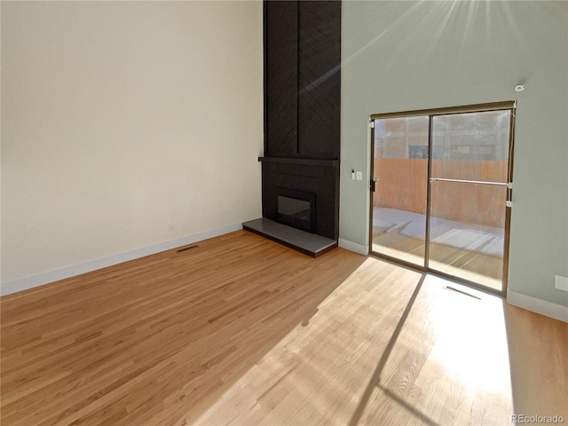 unfurnished living room with a fireplace and light hardwood / wood-style floors