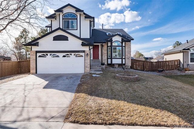 view of front facade featuring a fire pit, driveway, brick siding, and fence