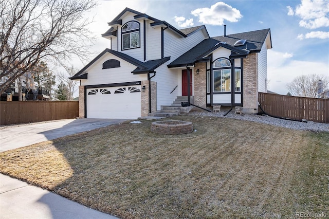 view of front facade with fence, concrete driveway, and brick siding